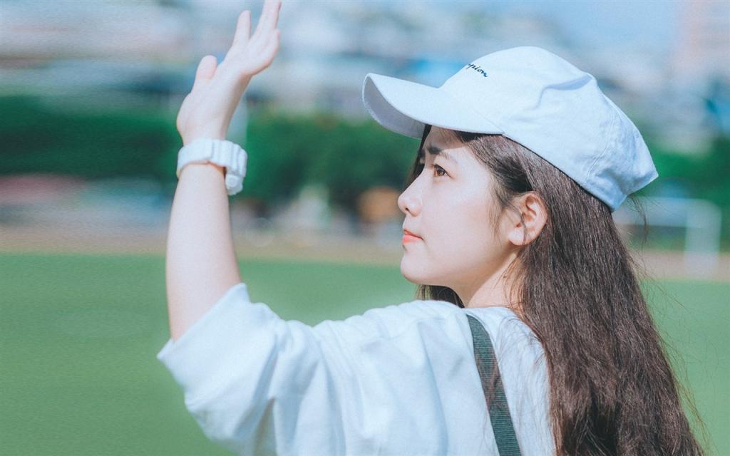 戴帽子的清纯美女户外草坪写真图片